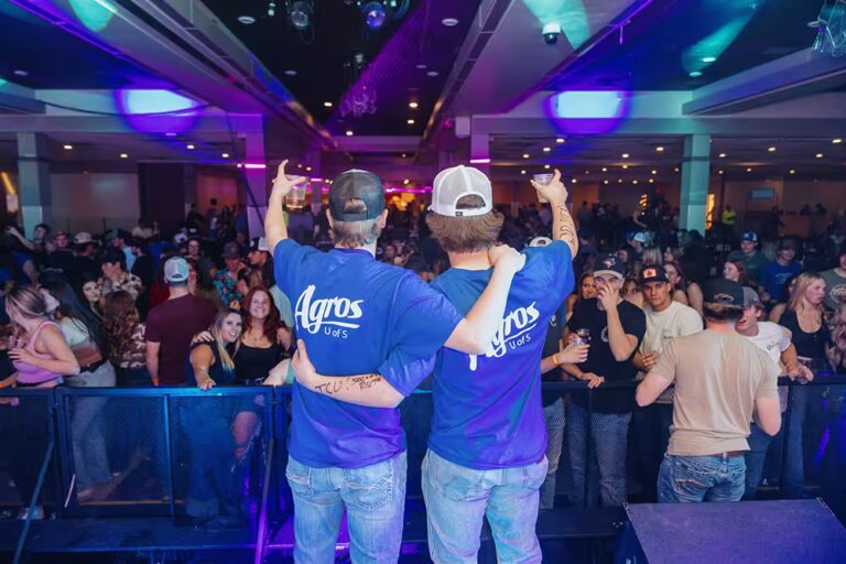 Two Agro members in front of large crowd at Ag Bag Drag event