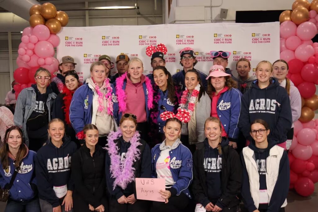 Group of Agros taking a photo infront of the CIBC Run For The Cure breast cancer event backdrop